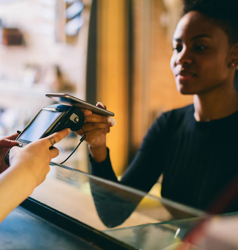 a woman does contactless payment with a digital wallet on her phone