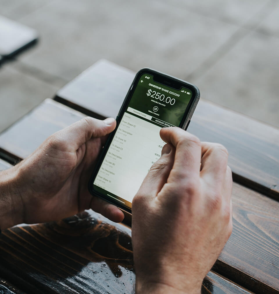 a finger taps a mobile phone showing an account balance