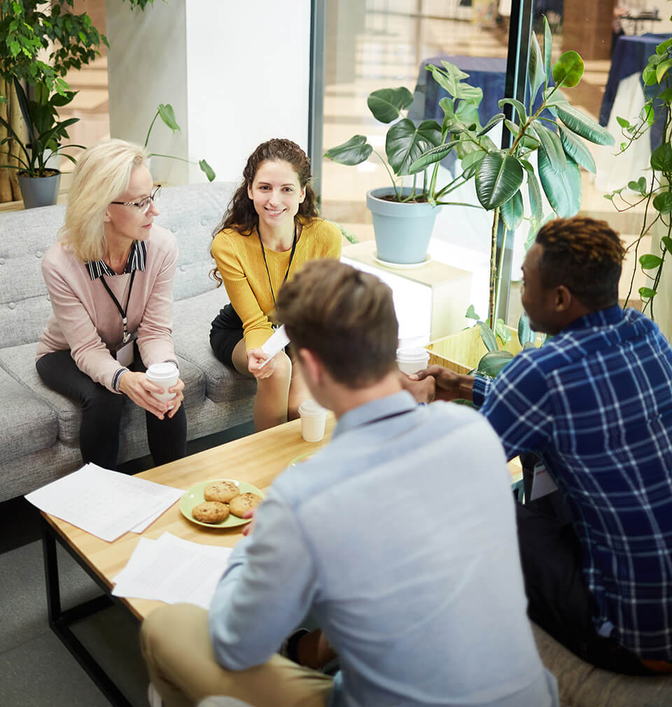 four young people gather round a table with cookies