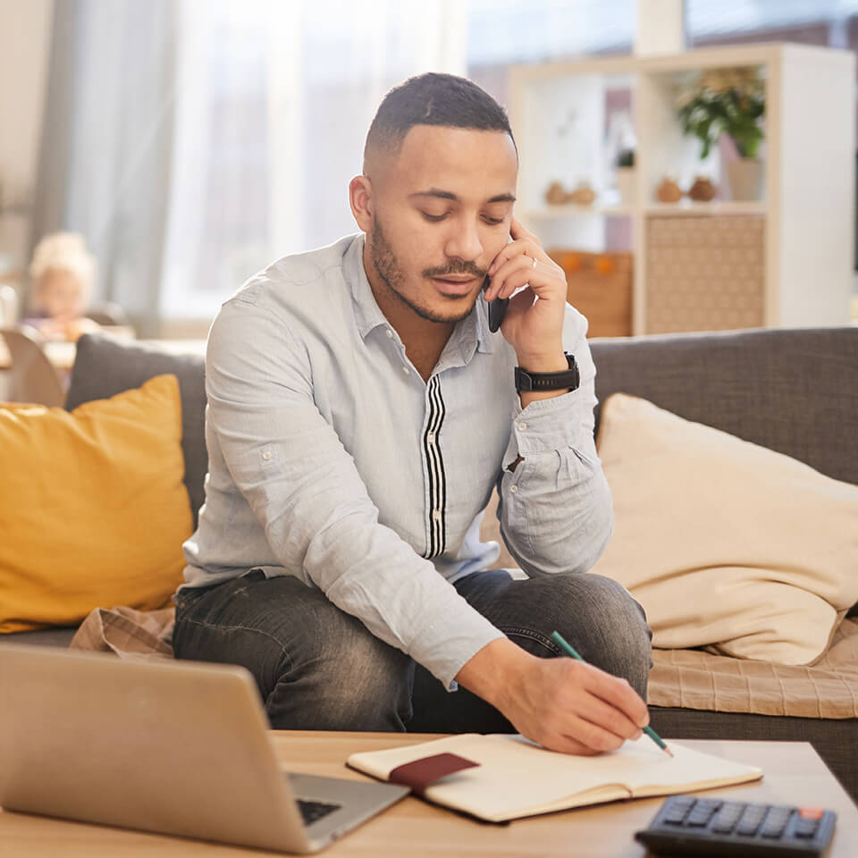 a man on the phone writes something down