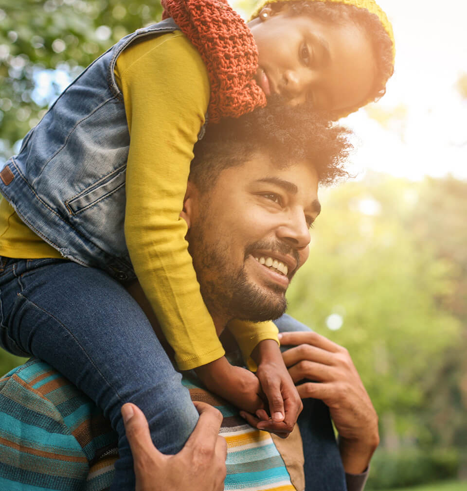 a father holds his son on his shoulders