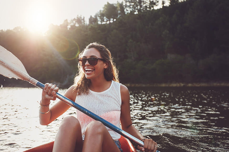 a smiling woman in a kayak on a river