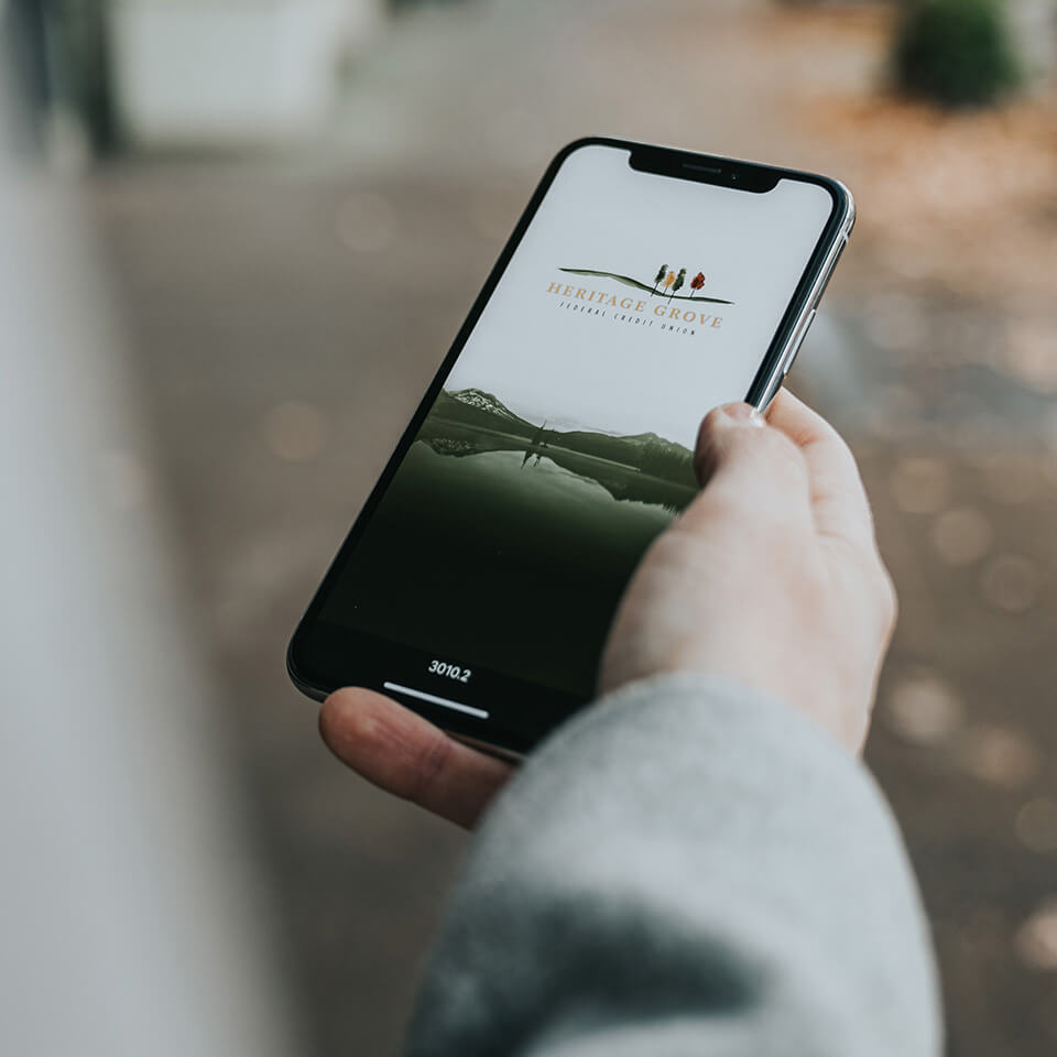 a hand holds a phone with a Heritage Grove lock screen