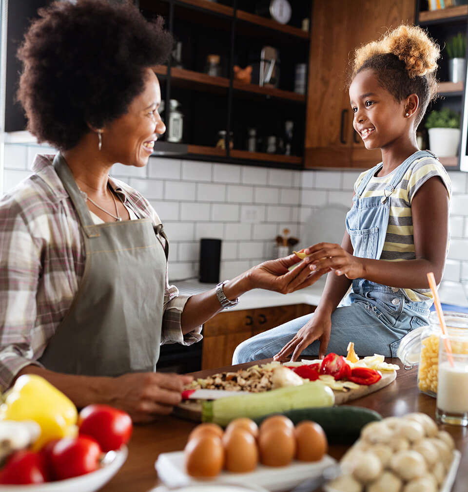 a mom and her daughter are cooking together