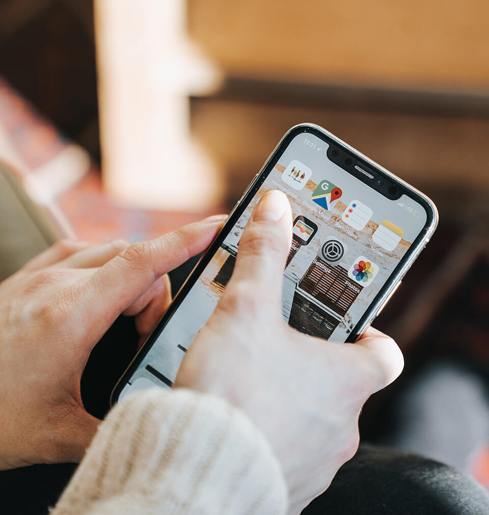 a person's hand uses their mobile phone