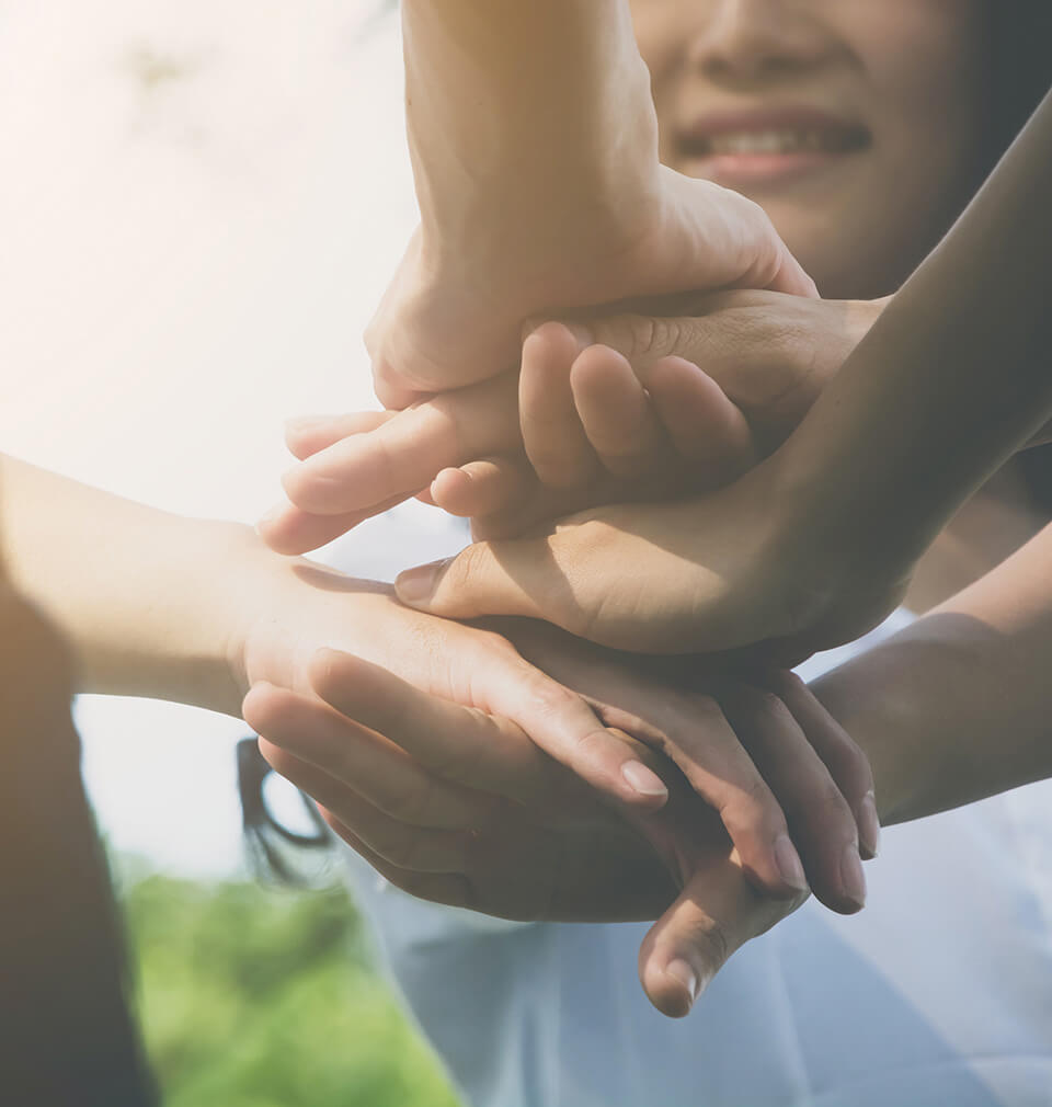 a few people holding hands on top of each other