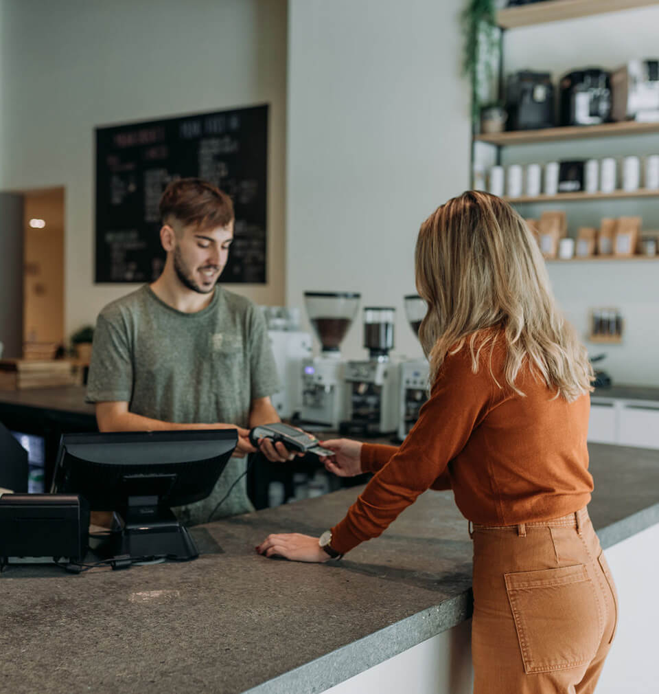 woman in orange outfit pays for something using her credit card