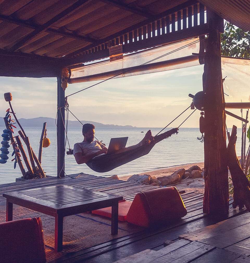a man in a hammock by the ocean