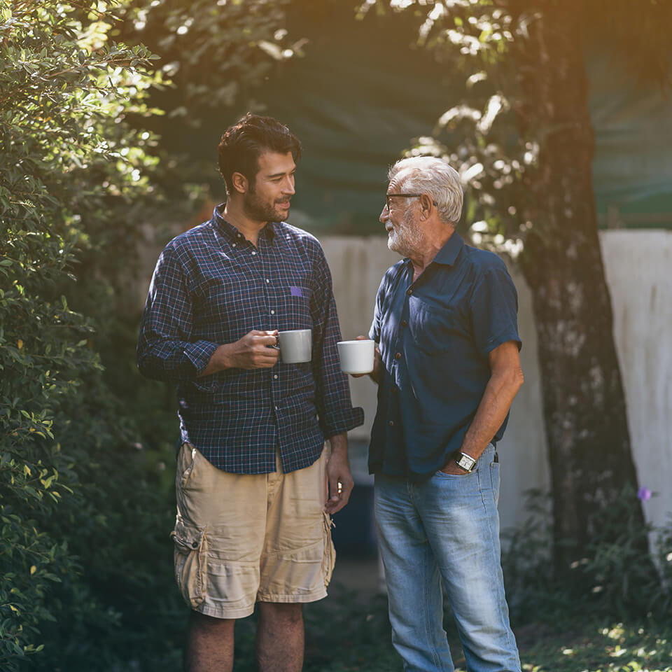 A father and son talking holding coffee